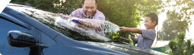 A father and son wash a car together.